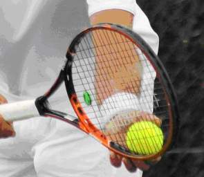 Tenisista trzyma piłkę i rakitę